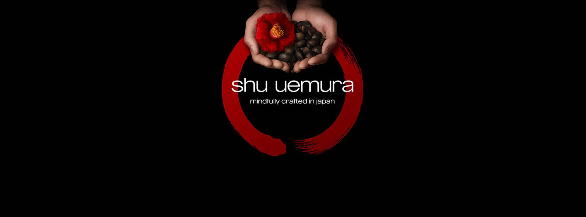 alt="Shu Uemura, mindfully crafted in Japan. Hands holding a red camellia flower and seeds, encircled by a red brush stroke representing Japanese heritage."