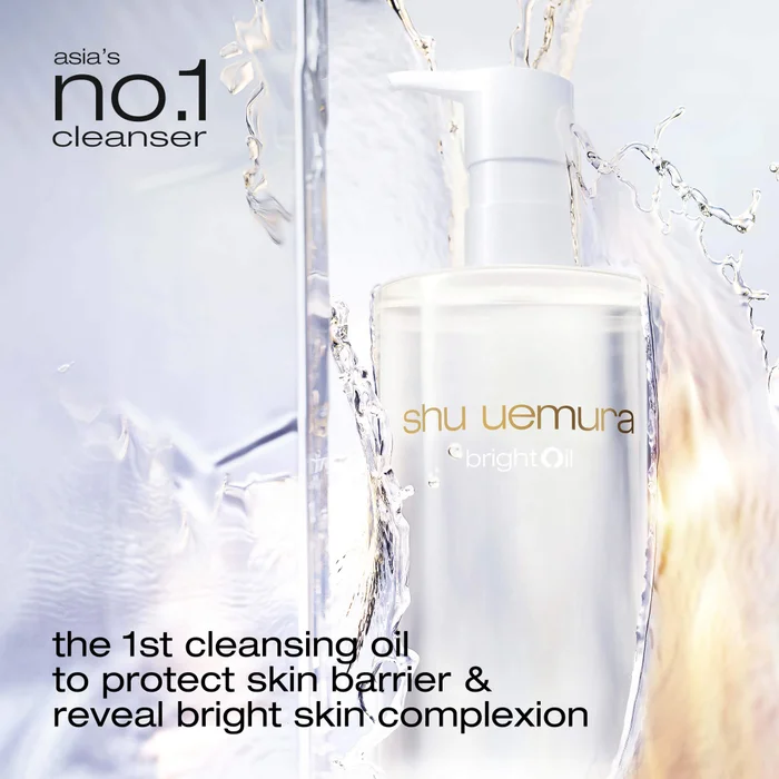 alt="Shu Uemura Bright Oil clear pump bottle surrounded by water splashes on a pale blue background, promoted as Asia's number one cleanser and the first cleansing oil to protect the skin barrier and reveal a bright complexion."